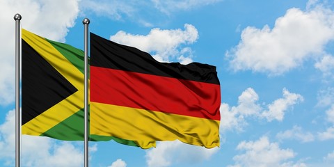 Jamaica and Germany flag waving in the wind against white cloudy blue sky together. Diplomacy concept, international relations.