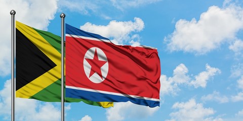 Jamaica and North Korea flag waving in the wind against white cloudy blue sky together. Diplomacy concept, international relations.