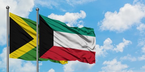 Jamaica and Kuwait flag waving in the wind against white cloudy blue sky together. Diplomacy concept, international relations.