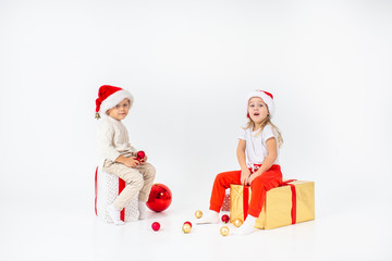 Happy little kids in Santa hat with Christmas gift boxes. Isolated on white background. Sale, holidays, christmas, new year, x-mas concept.