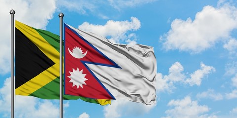 Jamaica and Nepal flag waving in the wind against white cloudy blue sky together. Diplomacy concept, international relations.