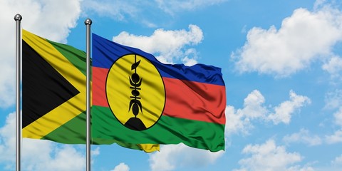 Jamaica and New Caledonia flag waving in the wind against white cloudy blue sky together. Diplomacy concept, international relations.