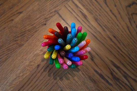 Felt tip pencils on wooden flooring with fish-bone pattern