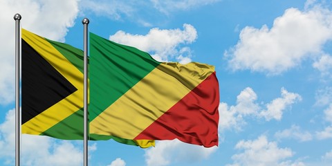 Jamaica and Republic Of The Congo flag waving in the wind against white cloudy blue sky together. Diplomacy concept, international relations.