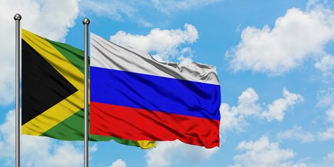 Jamaica and Russia flag waving in the wind against white cloudy blue sky together. Diplomacy concept, international relations.