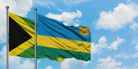 Jamaica and Rwanda flag waving in the wind against white cloudy blue sky together. Diplomacy concept, international relations.