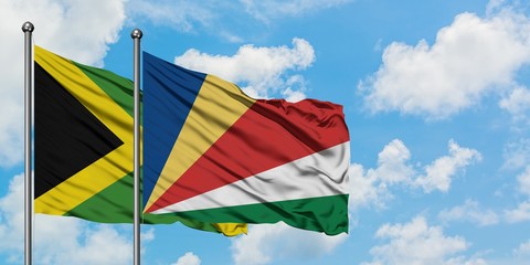 Jamaica and Seychelles flag waving in the wind against white cloudy blue sky together. Diplomacy concept, international relations.