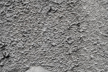 Cracked concrete grey wall covered with gray cement texture as background can be used in design. Dirty concrete texture with cracks and holes.