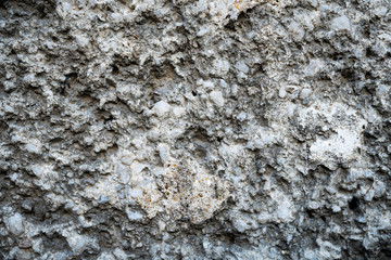 Texture of an old cracked concrete wall. Background image of a worn gray concrete surface