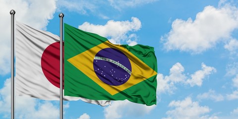 Japan and Brazil flag waving in the wind against white cloudy blue sky together. Diplomacy concept, international relations.