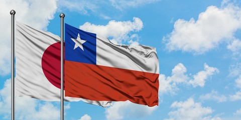 Japan and Chile flag waving in the wind against white cloudy blue sky together. Diplomacy concept, international relations.