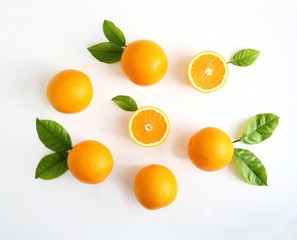 Oranges fruits composition with green leaves and slice on white wooden background, copy space.