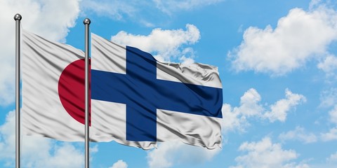 Japan and Finland flag waving in the wind against white cloudy blue sky together. Diplomacy concept, international relations.