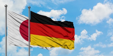 Japan and Germany flag waving in the wind against white cloudy blue sky together. Diplomacy concept, international relations.