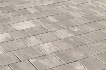 Paving slabs, stones of rectangular and square shapes of different colors laid out with patterns for equipping paths in the country as a background or texture