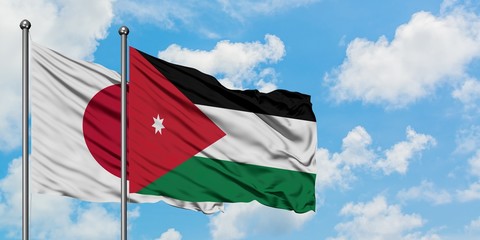 Japan and Jordan flag waving in the wind against white cloudy blue sky together. Diplomacy concept, international relations.