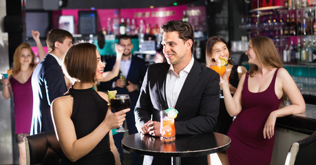Colleagues dancing on corporate party with cocktails in hands