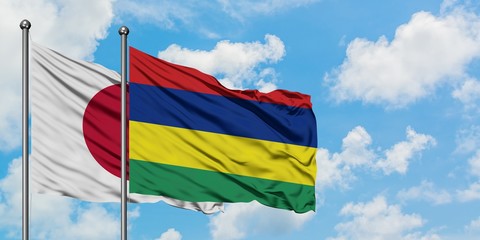 Japan and Mauritius flag waving in the wind against white cloudy blue sky together. Diplomacy concept, international relations.