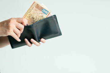 Hands picking Hong Kong money (Dollar Hong Kong or HKD) from short wallet for payment.