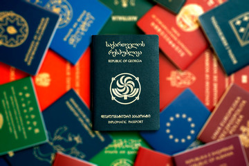 Georgian diplomatic passport on blurred multi-colored background of other passports of the world