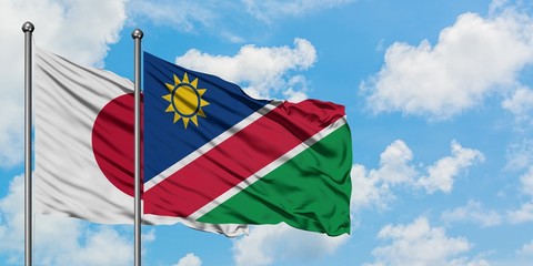 Japan and Namibia flag waving in the wind against white cloudy blue sky together. Diplomacy concept, international relations.