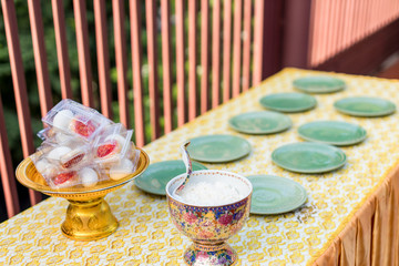 Offer food to monk. Groom give alms food to a Buddhist monk in traditional thai wedding ceremony. Hand while put food offerings in a Buddhist monk's alms bowl.Buddhists offer food in bowls.