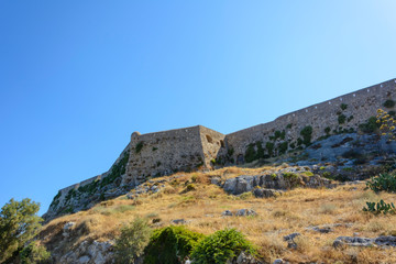 Fototapeta na wymiar view of the stone wall of the fortress of Fortezza on the mountain. Greece, Rethymno.