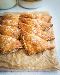 Homemade triangular pies made from ready-made puff pastry with apples