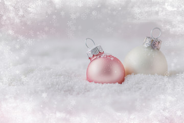 Silver and pink Christmas balls on snowy background, toned, selective focus