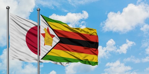 Japan and Zimbabwe flag waving in the wind against white cloudy blue sky together. Diplomacy concept, international relations.