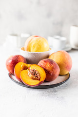Still life of plums and peaches on a white background