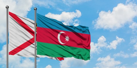 Jersey and Azerbaijan flag waving in the wind against white cloudy blue sky together. Diplomacy concept, international relations.