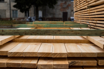 Piles of wooden boards in the sawmill, planking. Warehouse for sawing boards on a sawmill outdoors....