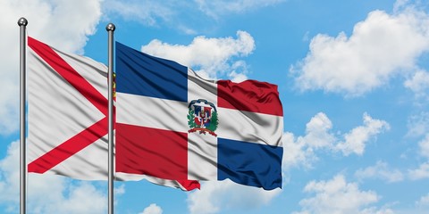 Jersey and Dominican Republic flag waving in the wind against white cloudy blue sky together. Diplomacy concept, international relations.