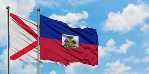 Jersey and Haiti flag waving in the wind against white cloudy blue sky together. Diplomacy concept, international relations.