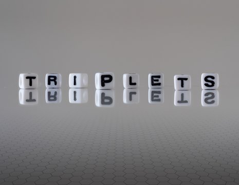 The concept of triplets represented by wooden letter tiles