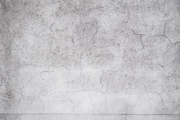 Cracked concrete grey wall covered with gray cement texture as background can be used in design. Dirty concrete texture with cracks and holes.
