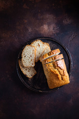 On a round wooden stand is a lean cupcake, a veggie raisin cupcake. Dark background. View from above