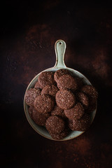 Chocolate cracked cookies with chocolate and sesame seeds. On a ceramic decorative dish