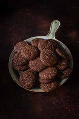 Chocolate cracked cookies with chocolate and sesame seeds. On a ceramic decorative dish