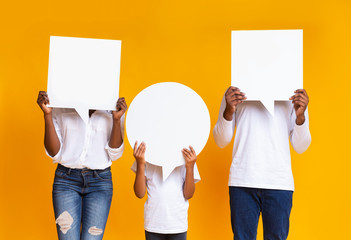 Black family of three covering faces with empty speech bubbles