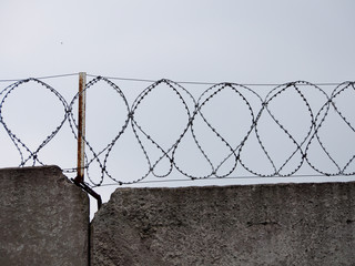 Coils of barbed wire against the gray sky.