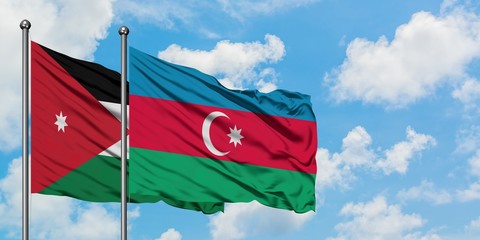 Jordan and Azerbaijan flag waving in the wind against white cloudy blue sky together. Diplomacy concept, international relations.