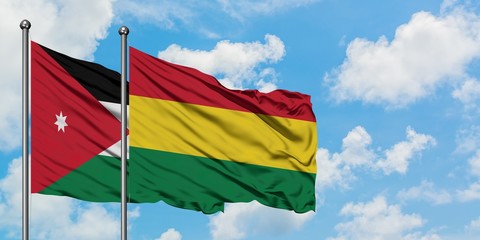 Jordan and Bolivia flag waving in the wind against white cloudy blue sky together. Diplomacy concept, international relations.