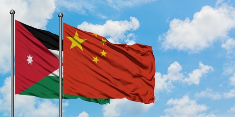 Jordan and China flag waving in the wind against white cloudy blue sky together. Diplomacy concept, international relations.