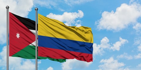 Jordan and Colombia flag waving in the wind against white cloudy blue sky together. Diplomacy concept, international relations.