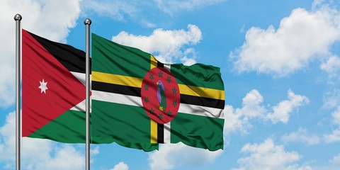 Jordan and Dominica flag waving in the wind against white cloudy blue sky together. Diplomacy...
