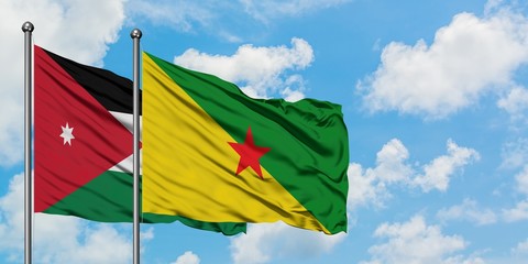 Jordan and French Guiana flag waving in the wind against white cloudy blue sky together. Diplomacy concept, international relations.