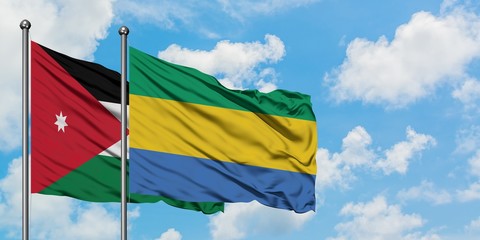 Jordan and Gabon flag waving in the wind against white cloudy blue sky together. Diplomacy concept, international relations.