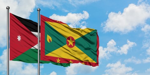 Jordan and Grenada flag waving in the wind against white cloudy blue sky together. Diplomacy concept, international relations.
